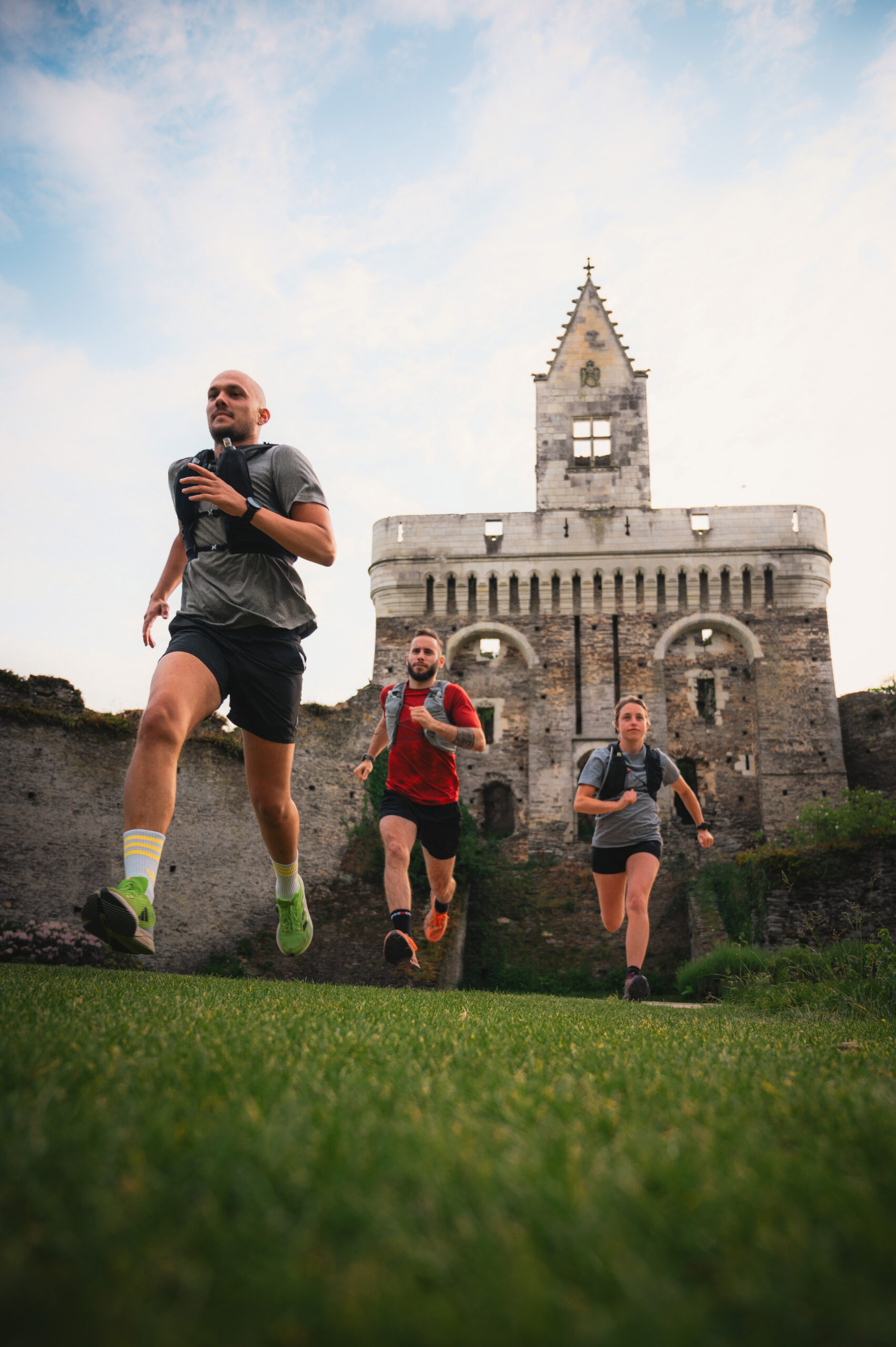 trois coureurs à pied devant le donjon du château